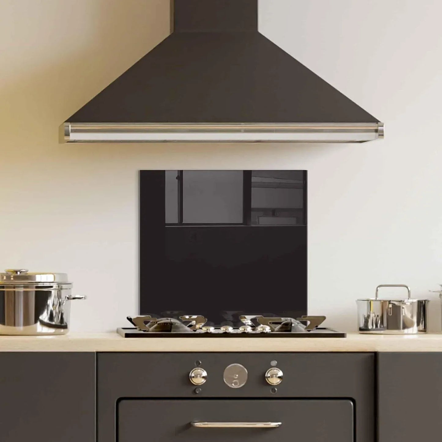 Black tempered glass kitchen backsplash behind gas stove in dark cabinetry